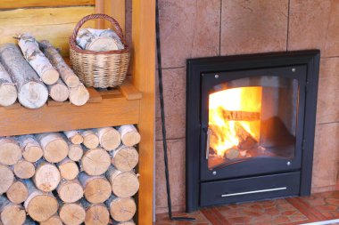 Şömine yakın odun yığını üzerinde huş çubuklarla küçük bir sepet.