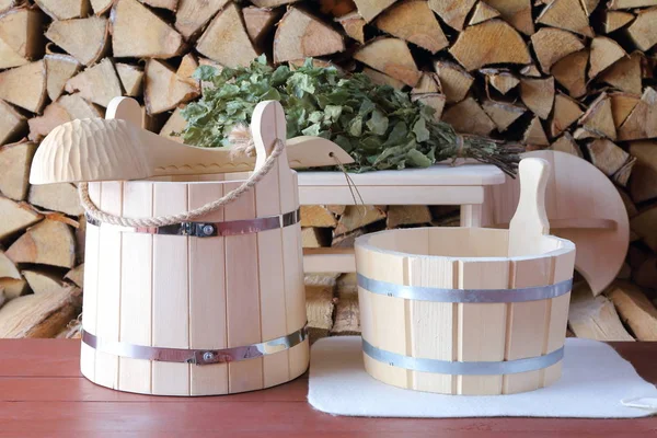 Odun yığınının arkasındaki sauna için ahşap aksesuarlar.. 