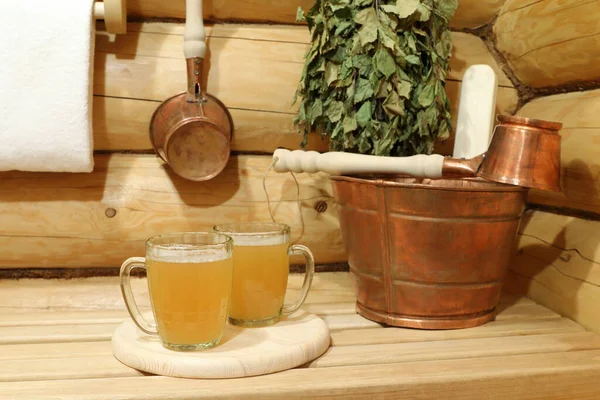 銅製のアクセサリーの間でサウナの内部に軽いビールの2つのガラスマグカップ — ストック写真