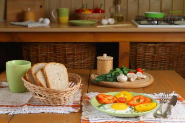 Mutfaktaki ahşap masada kızarmış yumurta ve taze sebzeler.. 