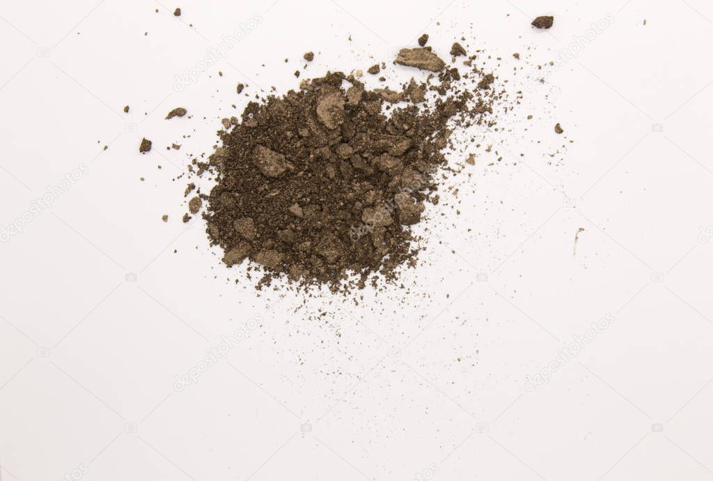 This is a photograph of a Dark Brown powder Eyeshadow isolated on a White background