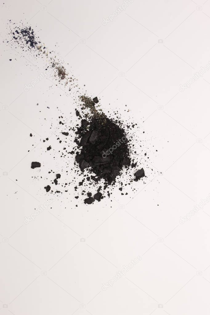 This is a photograph of Black powder Eyeshadow isolated on a White background