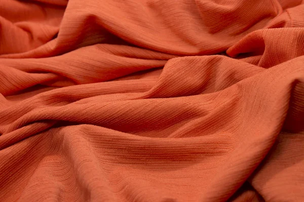 This is a photograph of textured neon Orange fabric background