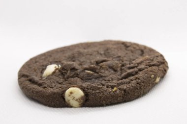 Bu, beyaz arka planda izole edilmiş beyaz çikolata parçalı çifte çikolatalı kurabiyenin fotoğrafı.