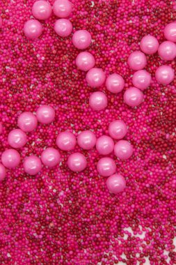 Bu, beyaz arka planda izole edilmiş pembe yuvarlak serpiştirilmiş bir fotoğraf.