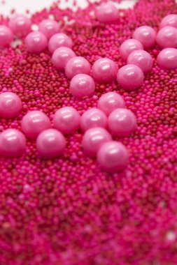 Bu, beyaz arka planda izole edilmiş pembe yuvarlak serpiştirilmiş bir fotoğraf.