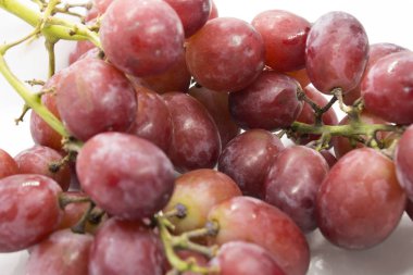 Bu kırmızı üzümlerin beyaz arka planda izole edilmiş bir fotoğrafı.