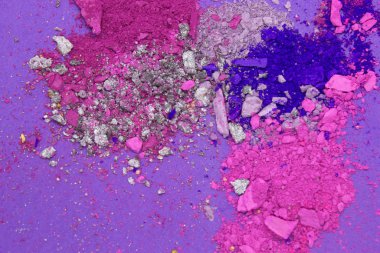 Bu Pembe, Mor, Mavi ve Gümüş tozunun Mor arka planda izole edilmiş bir fotoğrafı.