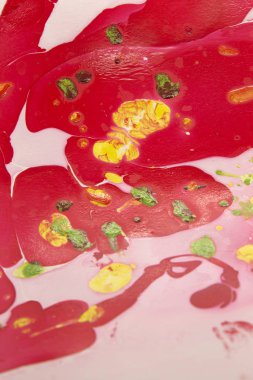 Bu, kırmızı, beyaz, sarı ve yeşil mermer bir tasarımın tırnak cilası kullanarak oluşturulan bir fotoğrafı.