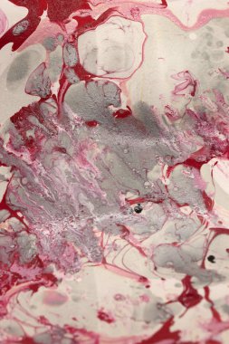 Bu, kırmızı, beyaz ve gri mermer bir tasarımın tırnak cilası kullanarak yaratılmış bir fotoğrafı.