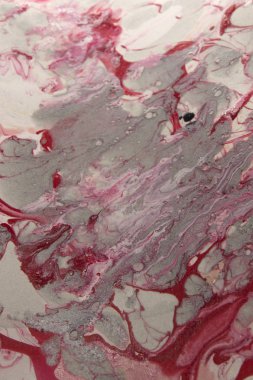 Bu, kırmızı, beyaz ve gri mermer bir tasarımın tırnak cilası kullanarak yaratılmış bir fotoğrafı.