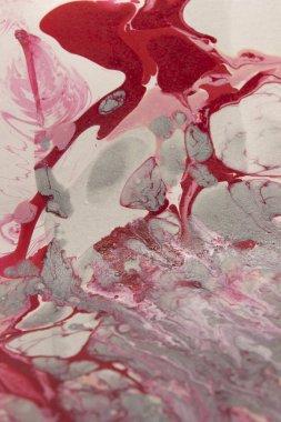Bu, kırmızı, beyaz ve gri mermer bir tasarımın tırnak cilası kullanarak yaratılmış bir fotoğrafı.