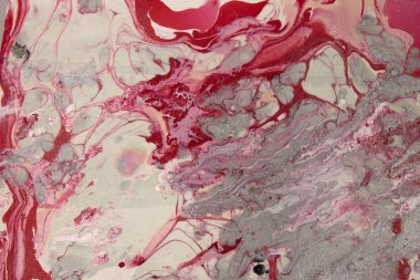 Bu, kırmızı, beyaz ve gri mermer bir tasarımın tırnak cilası kullanarak yaratılmış bir fotoğrafı.