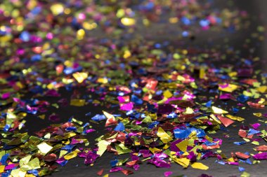 Bu, siyah arka plana yerleştirilmiş metalik renkli bir konfeti fotoğrafı.