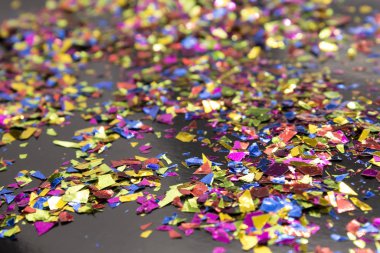 Bu, siyah arka plana yerleştirilmiş metalik renkli bir konfeti fotoğrafı.