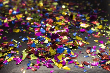 Bu, siyah arka plana yerleştirilmiş metalik renkli bir konfeti fotoğrafı.