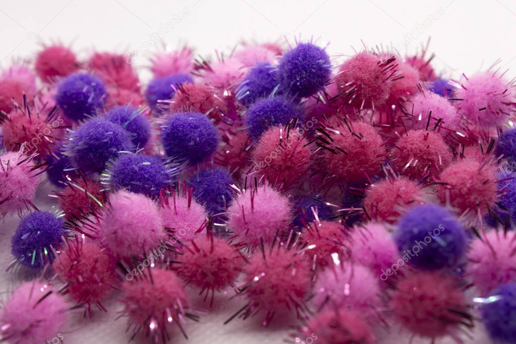 This is a photograph of Pink and Purple Pom Poms isolated on a White background