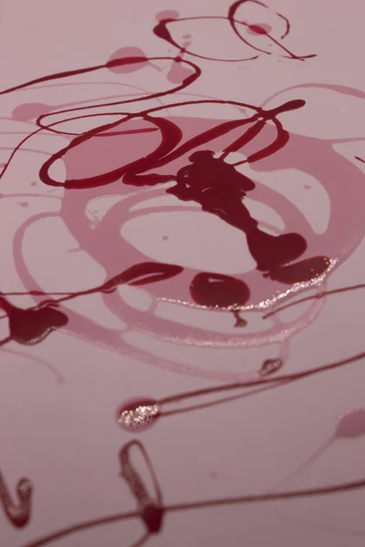 Фотография Розового Красного Лака Ногтей Разбрызганного Розовом Фоне — стоковое фото