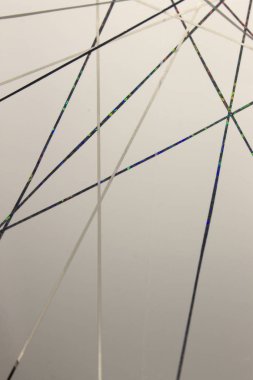 Bu, beyaz bir kağıda uygulanan siyah, gri bantla yaratılmış geometrik bir tasarımın fotoğrafı.