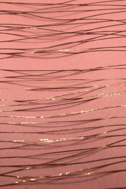 Bu, pembe bir kağıda uygulanan Rose altın bandı kullanılarak yapılmış geometrik bir tasarımın fotoğrafı.