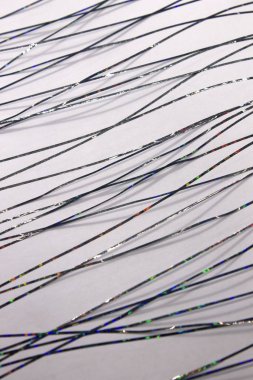 Bu, siyah metalik bantla oluşturulmuş soyut geometrik bir tasarımın Beyaz kağıda uygulanan bir fotoğrafı.