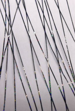 Bu, siyah metalik bantla oluşturulmuş soyut geometrik bir tasarımın Beyaz kağıda uygulanan bir fotoğrafı.