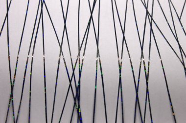 Bu, siyah metalik bantla oluşturulmuş soyut geometrik bir tasarımın Beyaz kağıda uygulanan bir fotoğrafı.