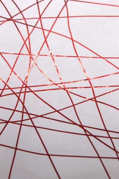 Bu, bir beyaz kağıda uygulanan kırmızı bant kullanılarak yaratılmış geometrik bir tasarımın fotoğrafı.