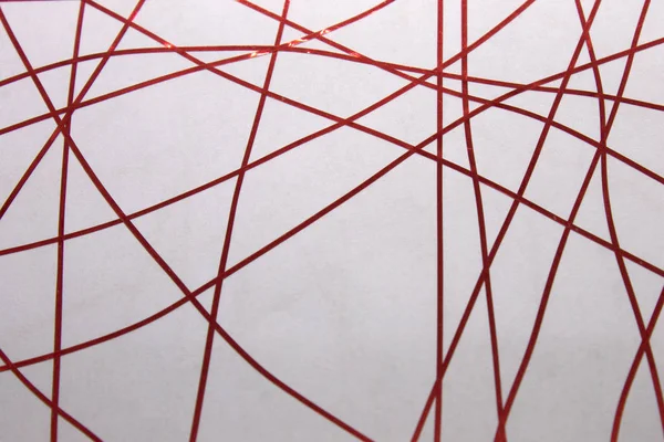 Bu, bir beyaz kağıda uygulanan kırmızı bant kullanılarak yaratılmış geometrik bir tasarımın fotoğrafı.