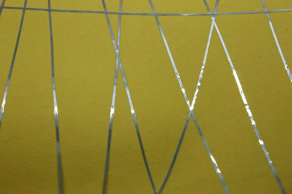 Bu, sarı bir kağıda uygulanan mavi bant kullanılarak yapılmış geometrik bir tasarımın fotoğrafı.