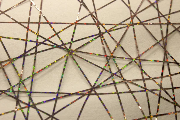 Bu renkli bantlarla bir kağıda uygulanan geometrik tasarımın fotoğrafı.