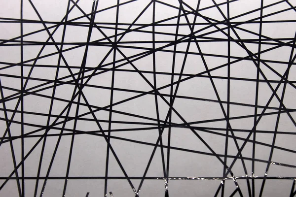 Bu, siyah bantla beyaz bir kağıda uygulanan geometrik bir tasarımın fotoğrafı.