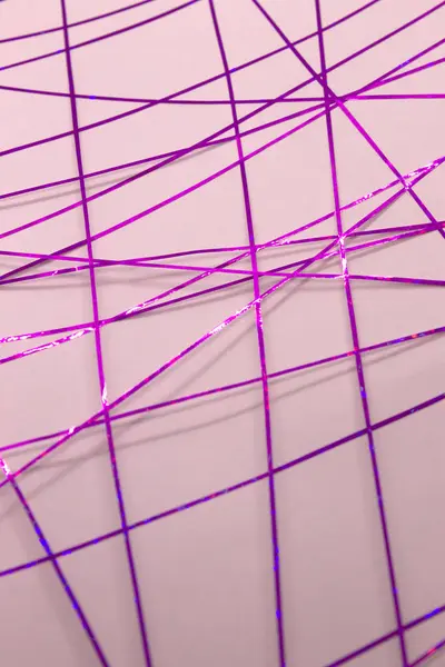 Bu, pembe bir kağıda uygulanan mor bant kullanılarak yapılmış geometrik bir tasarımın fotoğrafı.
