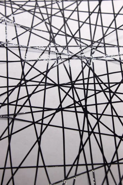 Bu, siyah bantla beyaz bir kağıda uygulanan geometrik bir tasarımın fotoğrafı.