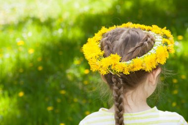 Dandelions başında bir çelenk ile küçük bir kız. Arkadan Görünüm.