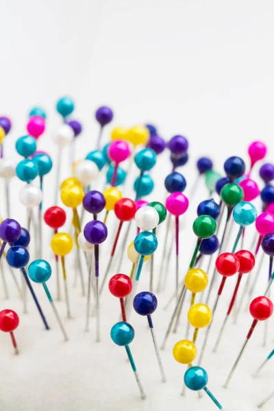 Multicolored sewing pins in the white pin cushion. Close-up — Stock Photo, Image
