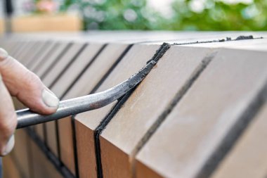 Duvarcı, tuğlalara bakarak yeni çitler inşa ediyor. Tuğlalar arası eklemlerin hizalanması