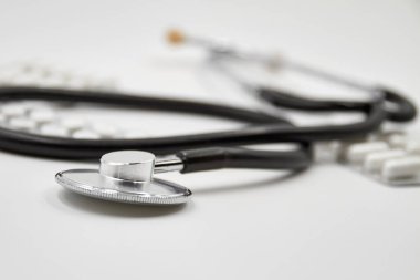 COVID-19 kavramı. Coronavirus hastalığı. Steteskop ve arka planda yakın plan çekilmiş haplar. Yakın çekim, seçici odaklanma