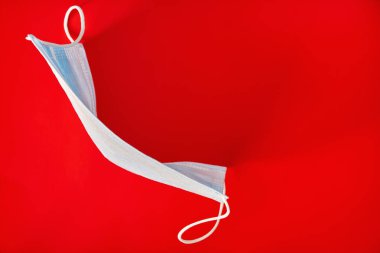 Covid-19 virüs enfeksiyonunu önlemek için maske, hijyen maskesi, kırmızı arka planda maske. Sağlık ve tıbbi konsept. Yakın çekim.