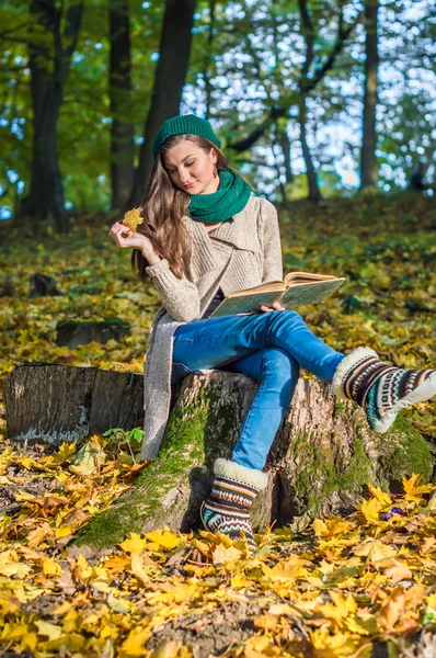 Glückliches Mädchen sitzt auf Baumstumpf — Stockfoto