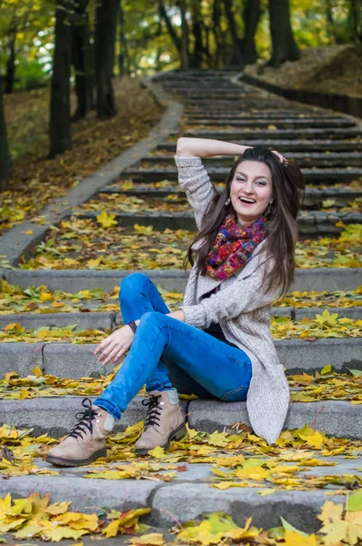 Chica sonriente sentada en las escaleras — Foto de Stock