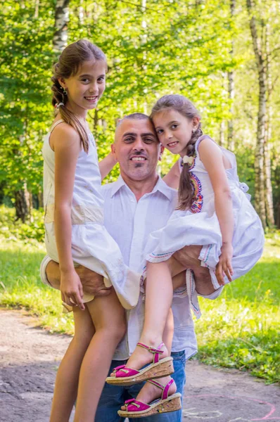 Daddy hugs his daughters