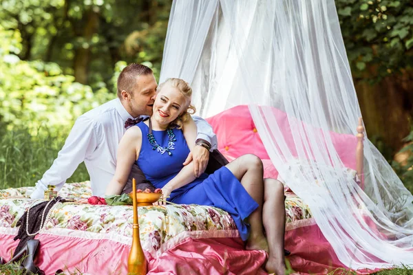 Um casal na cama no prado — Fotografia de Stock