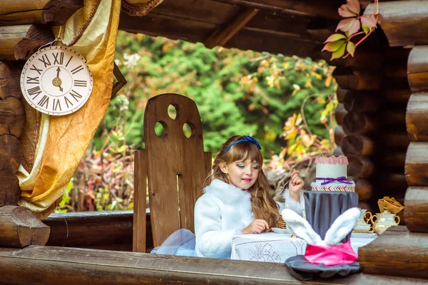 Vista frontal de uma menina bonita segurando um pedaço de bolo em uma colher na mesa — Fotografia de Stock