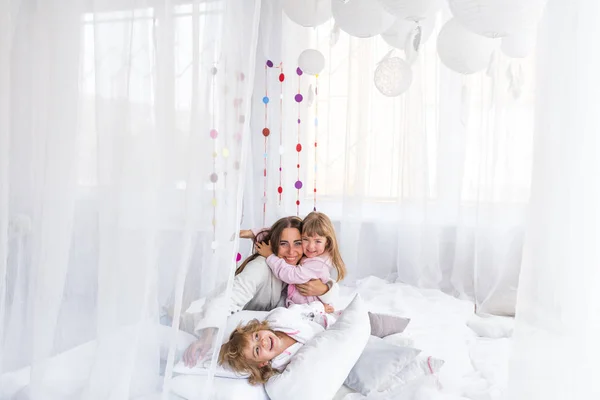 Mujer y niños en la cama — Foto de Stock