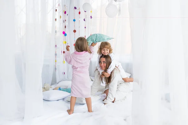 Mujer y niños en la cama — Foto de Stock