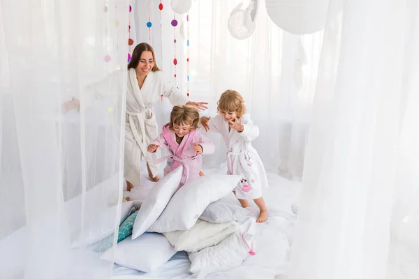 Mujer y niños en la cama — Foto de Stock