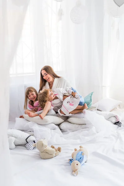 Mujer y niños en la cama — Foto de Stock