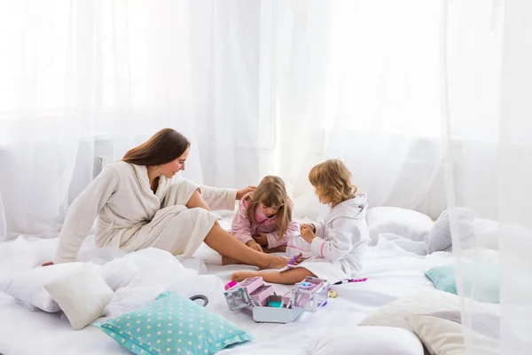 Mujer y niños en la cama — Foto de Stock