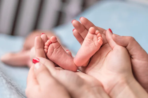 Bebis fötter i mor händer — Stockfoto